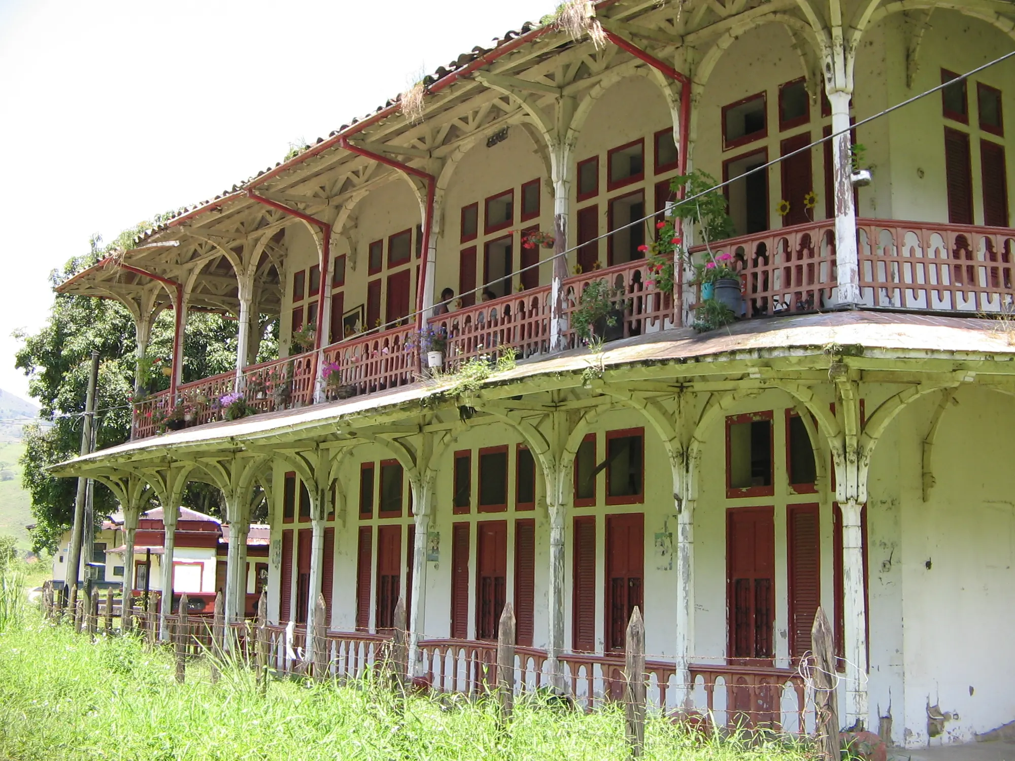 El antiguo Hotel de El Limón, de dos pisos, con balcones de madera y flores, a pleno sol