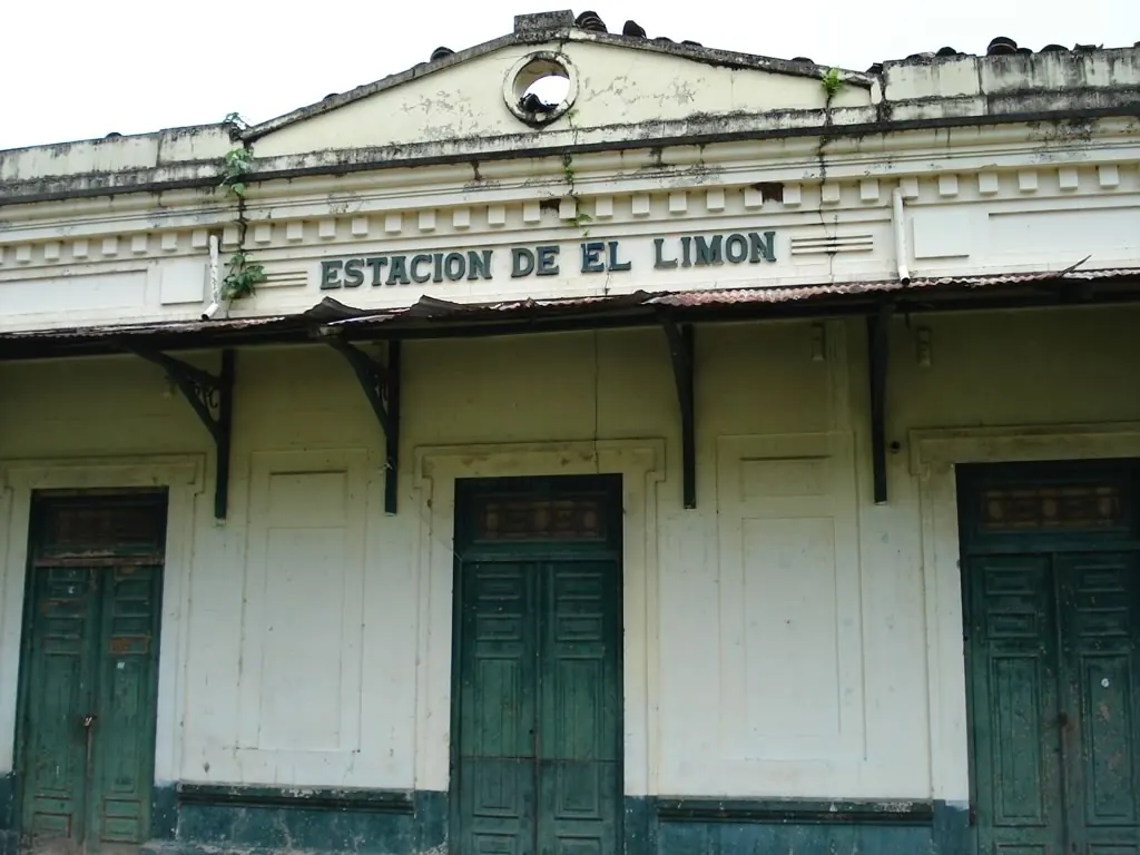 Letrero «Estación de El Limón» en el frontón del edificio, con puertas verdes de madera.