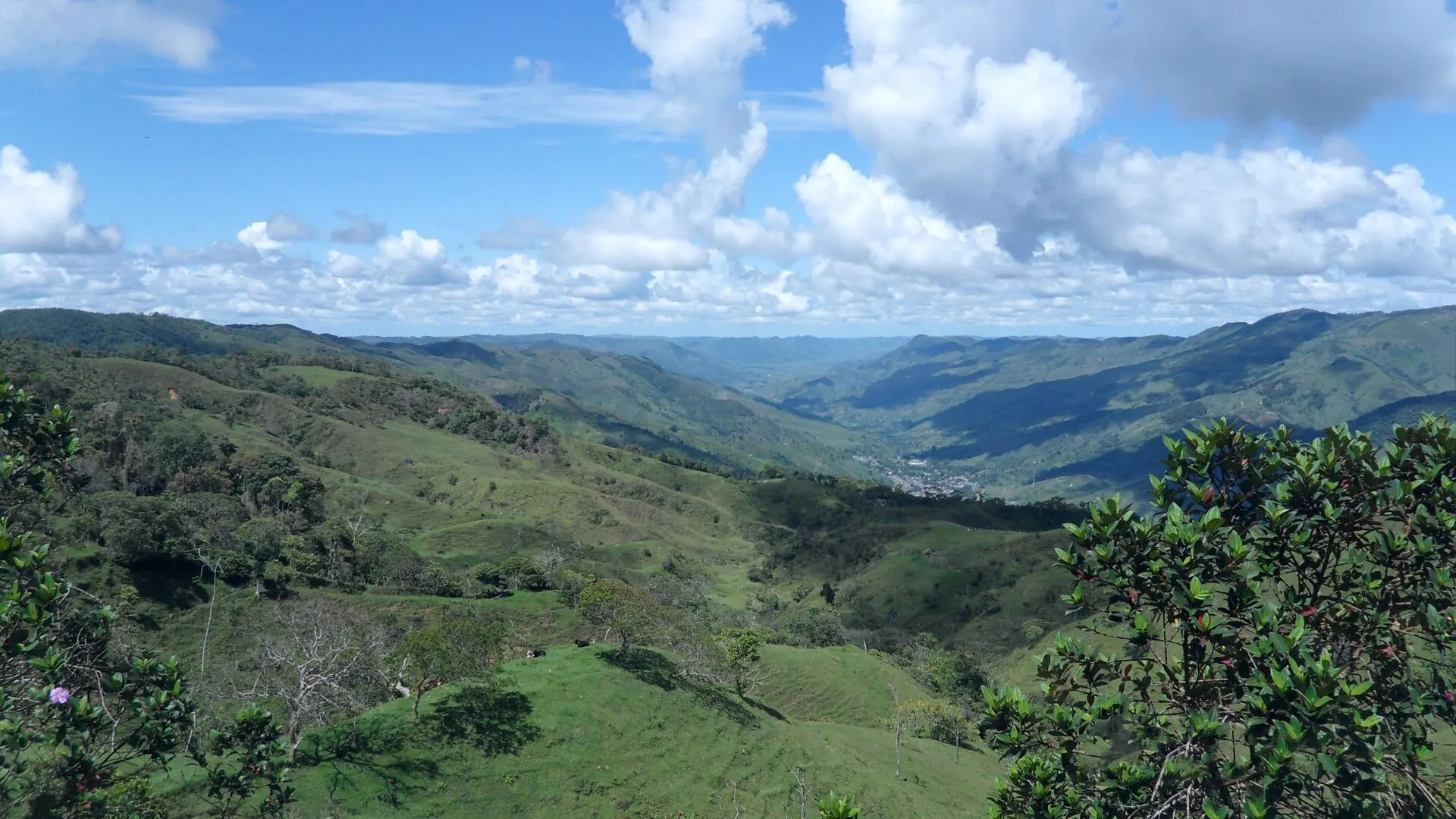 Paisaje de montañas y potreros con nubes, desde el sitio de La Quiebra entre Santo Domingo y Cisneros.